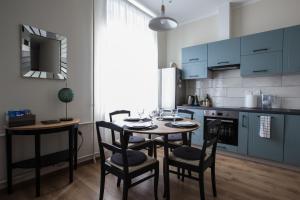 a kitchen with blue cabinets and a table and chairs at Cozy Home Valdemara, free parking, self check-in in Rīga