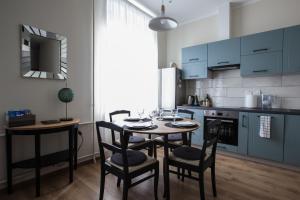 a kitchen with blue cabinets and a table and chairs at Cozy Home Valdemara, free parking, self check-in in Riga