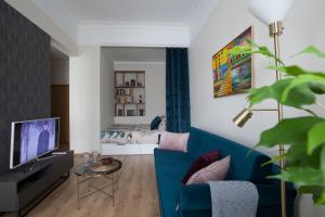 a living room with a blue couch and a bed at Cozy Home Valdemara, free parking, self check-in in Riga