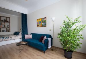 a living room with a blue couch and a plant at Cozy Home Valdemara, free parking, self check-in in Riga