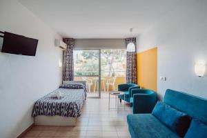 una sala de espera con sofá, mesa y sillas en Alper Apartments Mallorca, en Palmanova