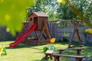 a playground with a slide and a play house at Dworek Zielińskich-Domki, Apartamenty, Podgrzewany basen, Parking in Rewal