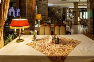 a table with a lamp and a table cloth on it at Hotel Bastion in Kostrzyn nad Odrą