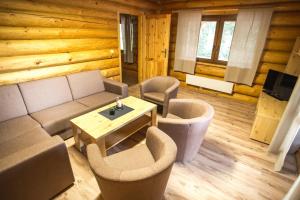 a living room with a couch and chairs and a table at Ubytovanie Dobšinská Ľadová Jaskyňa in Stratená