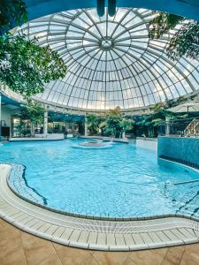 einem großen Pool in einem Gebäude mit Glasdecke in der Unterkunft Vital Hotel Frankfurt in Hofheim am Taunus