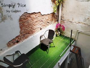 a room with two chairs on a green floor at 5imply 9ice Heritage in George Town