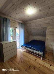 een slaapkamer met een bed in een blokhut bij LEŚNA OSTOJA in Rewal