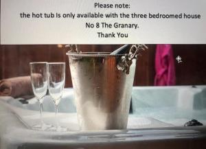 a bucket and two wine glasses sitting on a table at Skipbridge Farm Cottages in Green Hammerton