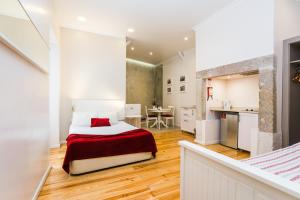 a small bedroom with a bed and a kitchen at Lisbon Arsenal Suites in Lisbon