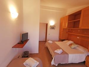 a hotel room with a bed, desk and television at Hotel Del Porto in Palau