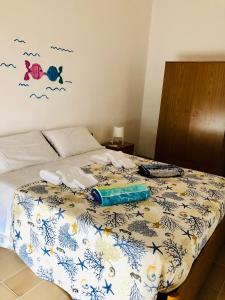 ein Schlafzimmer mit einem Bett mit einer Tagesdecke mit Fisch darauf in der Unterkunft Relax Near The Sea in Noto Marina