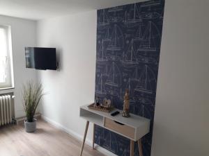 a living room with a wall with a blue and white wallpaper at Möwennest in Neuharlingersiel