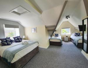 a bedroom with two beds and a tv in it at The Hedley Townhouse in Bournemouth