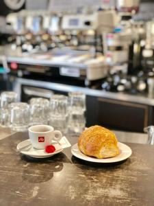 - une tasse de café et un croissant sur un comptoir dans l'établissement Hotel del Boschetto, à Poggiridenti