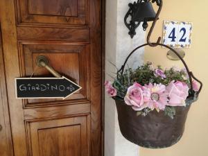 a bucket of flowers next to a door at jasmine cottage in Luni