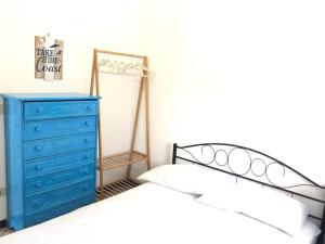 a bedroom with a blue dresser and a bed at Oasi del Pescatore in Marina di Cecina
