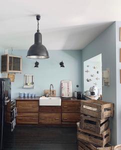 una cocina con armarios de madera y fregadero. en De la Chambre au Jardin, en Belleville-en-Beaujolais