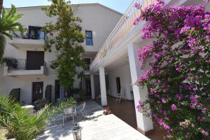 a courtyard of a house with purple flowers at Studio Apartments 6 Palmi in Budva