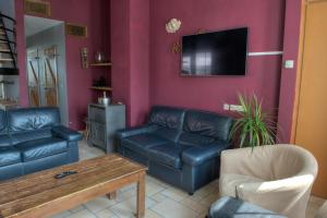 a living room with black leather furniture and a flat screen tv at Pelagie in Veurne