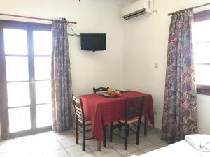 una sala da pranzo con tavolo e tovaglia rossa di Livadi center mountain view apartment a Livadi