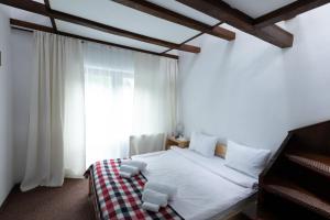 a bedroom with a bed and a large window at Club Rossignol in Poiana Brasov +47 photos