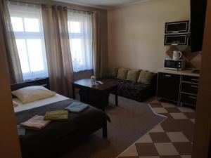 ein Schlafzimmer mit einem Bett, einem Tisch und einem Sofa in der Unterkunft Apartamenty Kostka in Karpacz