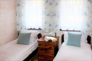 a bedroom with two beds and a desk with a book at Ośrodek Wczasowy Leśny Resort Mielno in Mielno