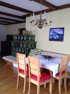 comedor con mesa, sillas y lámpara de araña en Haus zur Therme, en Bad Mitterndorf