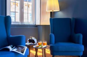 a blue room with two chairs and a table with drinks at Villa Cascais Boutique Hotel in Cascais