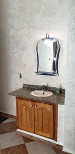 a bathroom with a sink and a mirror on the wall at Appartement Mus saidia in Saïdia