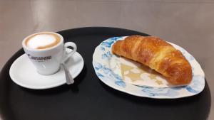 a plate with a pastry and a cup of coffee at Ostello Sociale Borgo Venno in Lavenone