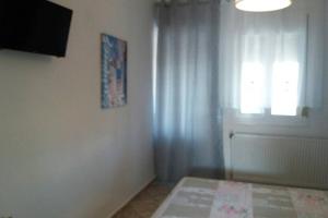 a bedroom with a bed and a window and a door at Zefis Appartment in Ouranoupoli