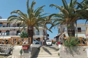 a row of palm trees in front of a building at Zefis Appartment in Ouranoupoli