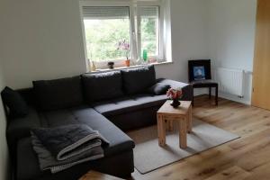 ein Wohnzimmer mit einem Sofa und einem Tisch in der Unterkunft Ferienhaus im Grünen in Brunshausen