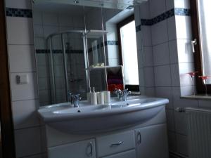 a bathroom with a white sink and a mirror at Haus zur Therme in Bad Mitterndorf