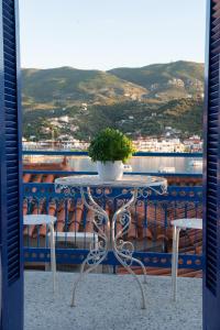 a table with a potted plant on top of a balcony at Poros Home in Poros