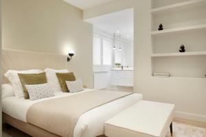 een witte slaapkamer met een groot wit bed en een bank bij Pikatxia by FeelFree Rentals in San Sebastian