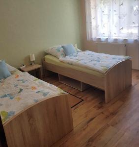 2 camas en una habitación con suelo de madera en Fewo Kaiser, en Wolmirstedt