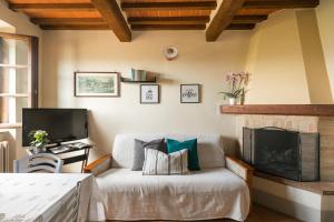 een woonkamer met een bank en een open haard bij Casa Franci in Contignano