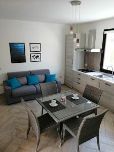 ein Wohnzimmer mit einem Tisch, Stühlen und einem Sofa in der Unterkunft Appartamento Monte Granatico 01 in SantʼAntìoco