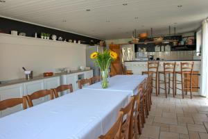 a dining room with a table with a vase of flowers on it at Pelagie in Veurne