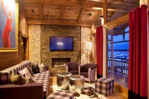 a living room with a fireplace and a tv at Feriendorf Oberhof in Flachau