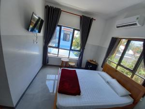 クアンガイにあるPhu Loc Motelのベッドと2つの窓がある寝室