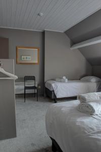 a hotel room with two beds and a chair at Pelagie in Veurne