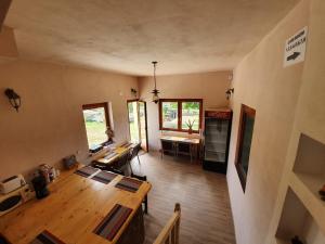 a living room with a wooden table and a kitchen at PENSIUNEA LEIA Transfăgărășan in Cârțișoara