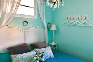 a bedroom with blue walls and a bed and a chandelier at CHARMANT HOME - Mariesol in Nice