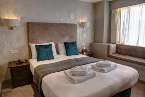 a hotel room with a bed with towels on it at The Orwell Hotel in Felixstowe