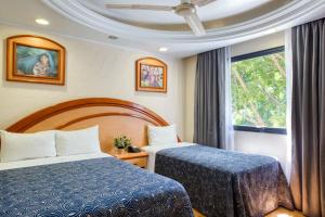 a hotel room with two beds and a window at Hotel Diligencias in Mexico City