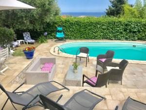 a swimming pool with chairs and a table and a group ofatoes at Villa Provençale in La Turbie