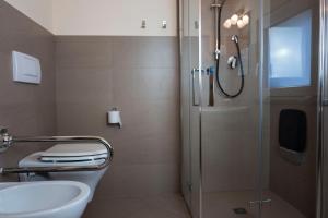 a bathroom with a shower and a toilet and a sink at Foresteria La Merlina in Borgo Adorno +26 photos